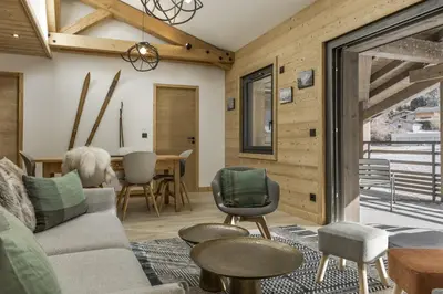 a living room with a couch and a table at Nid d'Aigle - Balcon avec vue Mont Blanc in Les Houches