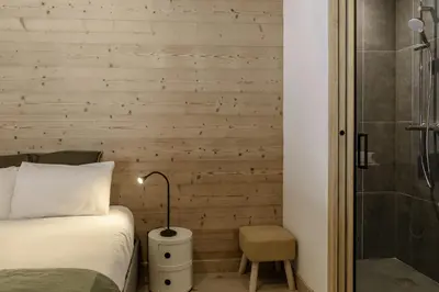 a bedroom with a bed and a shower at Nid d'Aigle - Balcon avec vue Mont Blanc in Les Houches