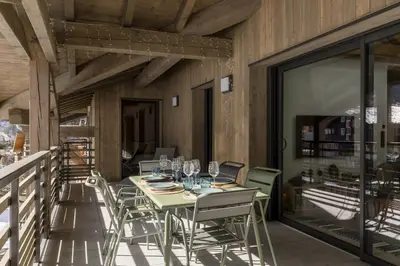 a dining room with a table and chairs on a balcony at Nid d'Aigle - Balcon avec vue Mont Blanc in Les Houches