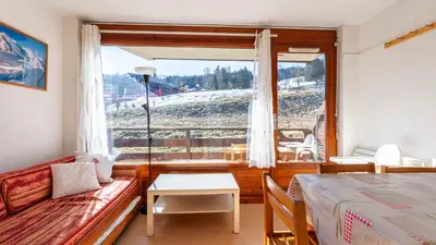 a room with a couch and a table and a window at Les Eterlous N07 - 2P5 in Morillon