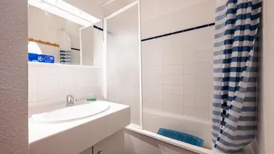 a white bathroom with a sink and a shower at Les Eterlous N07 - 2P5 in Morillon