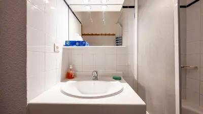 a white bathroom with a sink and a mirror at Les Eterlous N07 - 2P5 in Morillon