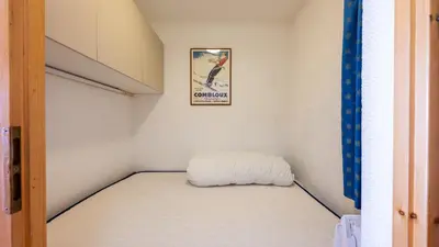 a small bed in a room with a picture on the wall at Les Eterlous N07 - 2P5 in Morillon