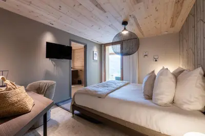a bedroom with a large bed and a couch at Chalet Eteila vue incroyable ! Combloux 10 min de Megève in Combloux