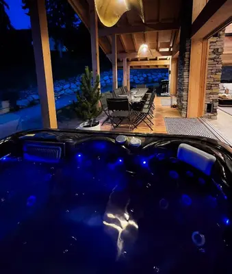 a hot tub in the middle of a patio at night at Chalet Eteila vue incroyable ! Combloux 10 min de Megève in Combloux