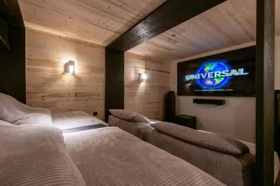 a room with two beds and a television on the wall at Chalet Eteila vue incroyable ! Combloux 10 min de Megève in Combloux