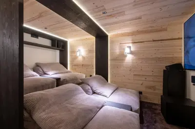 three beds in a room with wooden walls at Chalet Eteila vue incroyable ! Combloux 10 min de Megève in Combloux