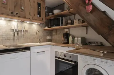 a kitchen with white appliances and wooden cabinets at Les Arolles - Duplex familial - Vue montagne in Les Houches