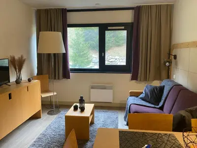 a living room with a couch and a tv at Havre de paix à Flaine in Arâches-la-Frasse