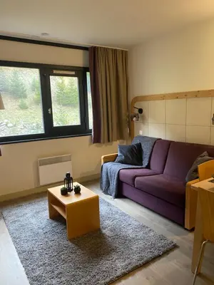 a living room with a purple couch and a coffee table at Havre de paix à Flaine in Arâches-la-Frasse