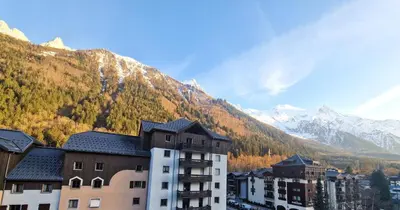 a building with a mountain in the background at La Floria, Vue Mont Blanc in Chamonix-Mont-Blanc