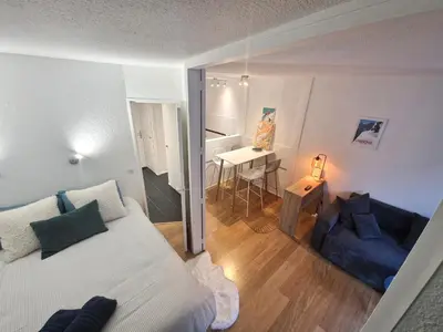a bedroom with a bed and a living room with a desk at La Floria, Vue Mont Blanc in Chamonix-Mont-Blanc