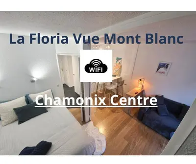 a room with a bed and a living room with a sign at La Floria, Vue Mont Blanc in Chamonix-Mont-Blanc
