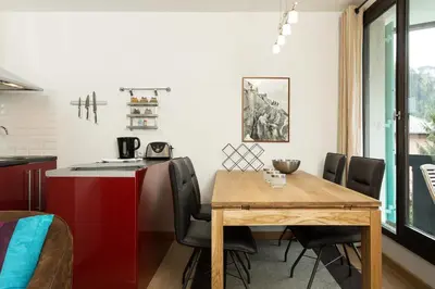 a kitchen and dining room with a wooden table and chairs at Apartment Balme 3B - A Chamonix Mont Blanc Haven in Chamonix-Mont-Blanc