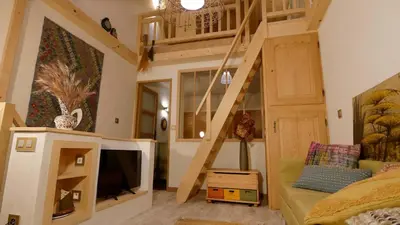 a living room with a loft bed and a tv at L'ENVOLéE in Samoëns