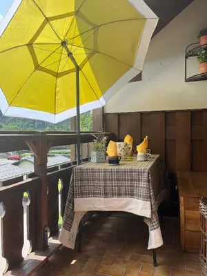 a table with a yellow umbrella on a patio at L'ENVOLéE in Samoëns