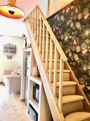a staircase in a living room with a flowered wall at L'ENVOLéE in Samoëns