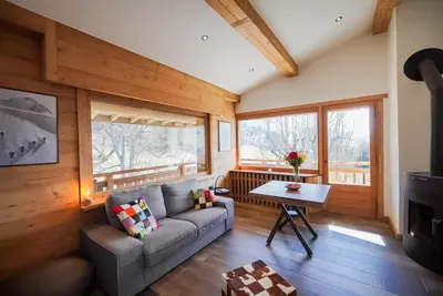 a living room with a couch and a table at Elégance Alpine - Proche centre de Megève in Megève