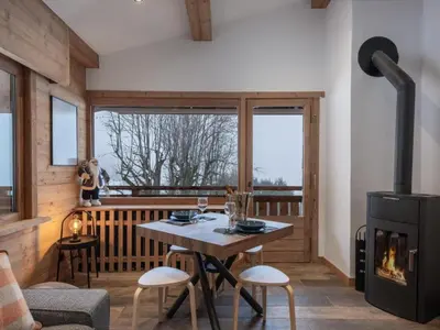 a kitchen with black cabinets and a sink at Elégance Alpine - Proche centre de Megève in Megève