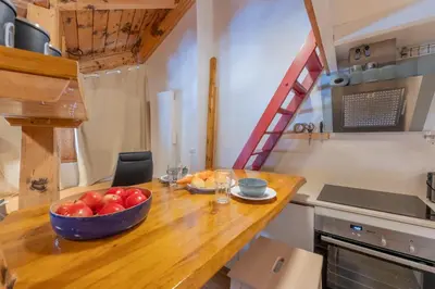 a kitchen with a bowl of fruit on a wooden table at Résidence Grand Roc - Ancolies 348 - Happy Rentals in Chamonix-Mont-Blanc