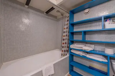a bathroom with blue shelves and a bath tub at Résidence Grand Roc - Ancolies 348 - Happy Rentals in Chamonix-Mont-Blanc
