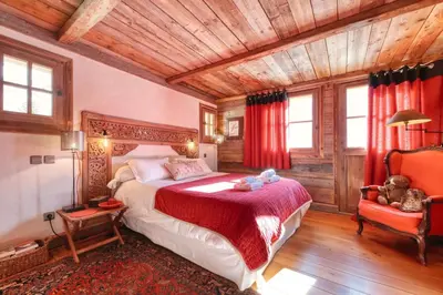 a bedroom with a large bed and a chair at Chalet Foret Rouge in Chamonix-Mont-Blanc