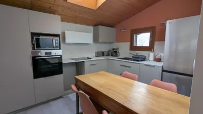 a kitchen with a wooden table and a counter top at les Cristaux in Combloux