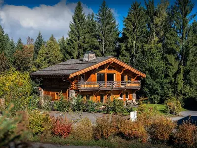 a large log cabin in the woods with trees at Chalet Ellambra - OVO Network in Combloux