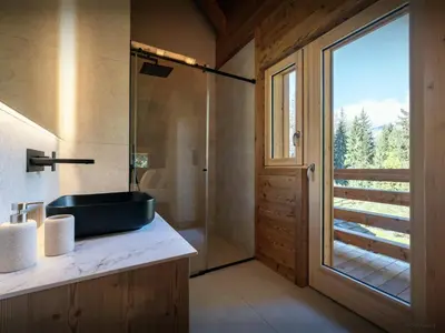 a bathroom with a sink and a glass shower at Chalet Ellambra - OVO Network in Combloux