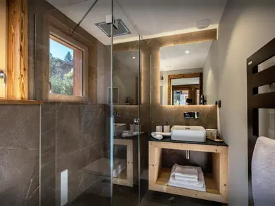 a bathroom with a glass shower and a sink at Chalet Ellambra - OVO Network in Combloux
