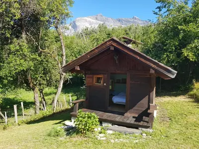 a small cabin with a bed in the grass at Petit mazot savoyard in Servoz