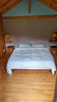 a large bed in a room with two tables at Petit mazot savoyard in Servoz