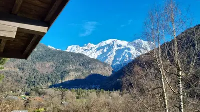 a view of a snow covered mountain from a house at Petit mazot savoyard in Servoz
