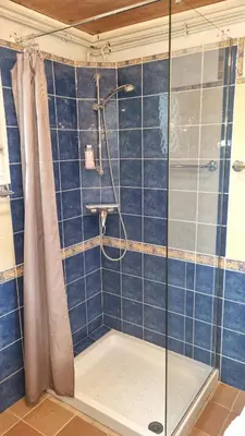 a bathroom with a shower with blue tiles at Petit mazot savoyard in Servoz