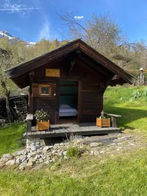a small cabin with a bed in a field at Petit mazot savoyard in Servoz