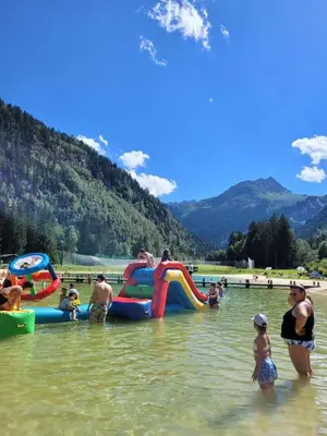 a group of people in the water at a beach at Le Cocon des Cîmes in Les Contamines-Montjoie