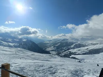 a view of a snow covered ski slope with mountains at Le Cocon des Cîmes in Les Contamines-Montjoie