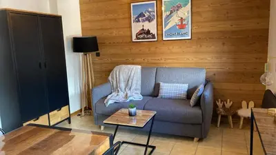 a living room with a couch and a table at Le Cocon des Cîmes in Les Contamines-Montjoie
