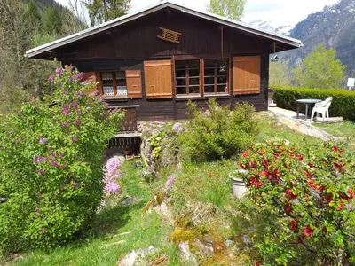 a house on a hill with flowers in front of it at Les Vardasses - Chalet typique avec jardin et vue sur les montagnes in Les Houches