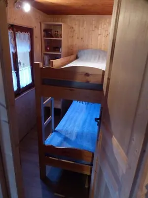 a small room with a bunk bed in a tiny house at Les Vardasses - Chalet typique avec jardin et vue sur les montagnes in Les Houches