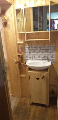 a bathroom with a sink and wooden cabinets at Les Vardasses - Chalet typique avec jardin et vue sur les montagnes in Les Houches