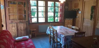 a living room with a table and chairs and a couch at Les Vardasses - Chalet typique avec jardin et vue sur les montagnes in Les Houches