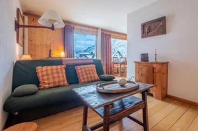 a living room with a green couch and a table at Nice apartment with Mont Blanc balcony's view in Chamonix-Mont-Blanc