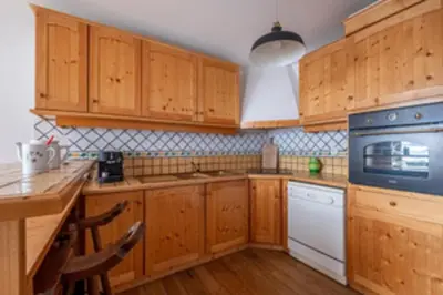 a kitchen with wooden cabinets and a blue appliance at Nice apartment with Mont Blanc balcony's view in Chamonix-Mont-Blanc