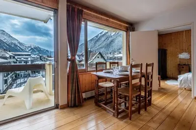 a dining room with a table and a large window at Nice apartment with Mont Blanc balcony's view in Chamonix-Mont-Blanc