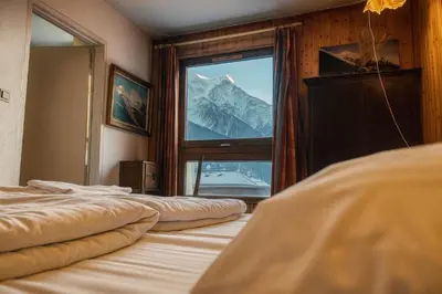 a bedroom with two beds and a window with a mountain at Nice apartment with Mont Blanc balcony's view in Chamonix-Mont-Blanc