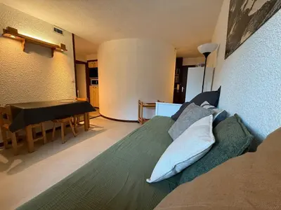 a bedroom with a bed and a table and a dining room at Joli 2P Mummery centre-ville de Chamonix in Chamonix-Mont-Blanc