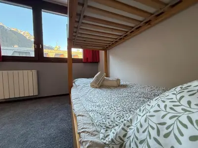 a bedroom with a bed and a large window at Joli 2P Mummery centre-ville de Chamonix in Chamonix-Mont-Blanc