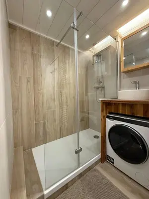 a bathroom with a shower and a washing machine at Joli 2P Mummery centre-ville de Chamonix in Chamonix-Mont-Blanc