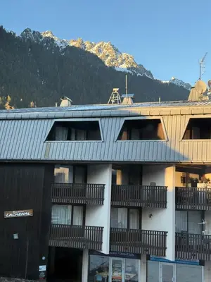 an apartment building with a mountain in the background at Joli 2P Mummery centre-ville de Chamonix in Chamonix-Mont-Blanc